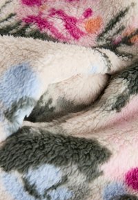 Fleece deken in tinten roze, blauw en groen, met een zachte, gestructureerde oppervlakte en een bloemenpatroon met kleurvariaties.