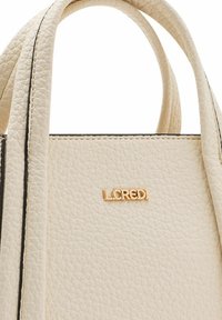 Borsa in pelle di colore crema con texture, logo dorato e bordi neri a contrasto. Presenta doppi manici e un design strutturato.