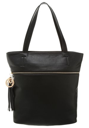 Czarna skórzana torba typu tote z górnym zamkiem błyskawicznym, płaską podstawą, dwoma uchwytami oraz ozdobą w postaci frędzla z okrągłym brelokiem. Gładka faktura, prosty design.