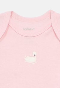 Ροζ βαμβακερό κορμάκι με μικρό λευκό γραφικό κύκν ου και στρογγυλεμένη λαιμόκοψη με κοντά μανίκια. Απαλή υφή με ελάχιστες ραφές.