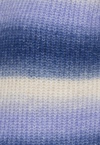 Stickad tyg med en ombre-mönster som övergår från ljus grädde till djup marinblå, som visar olika nyanser av blått och en mjuk textur.