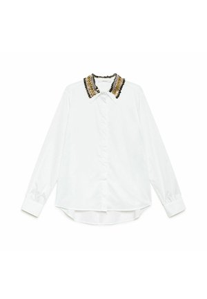 Chemise blanche à manches longues avec un col orné de perles aux accents dorés et noirs, coupe structurée, texture subtile, et fermeture boutonnée sur le devant.