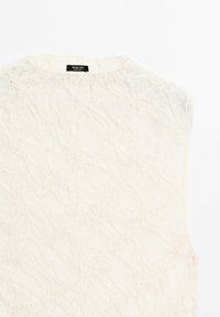 Blouse blanche sans manches avec un motif floral texturé subtil et un col rond de Massimo Dutti.