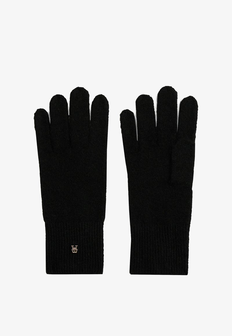 Gants noirs tricotés avec des poignets côtelés, réalisés dans un tissu doux. Les caractéristiques incluent un poignet replié et un petit logo sur un des gants.