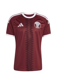 Bordo nogometna majica s bijelim detaljima, sa žižak uzorkom duž središnjeg dijela i logotipom na prsima. Izrađena od prozračnog materijala.