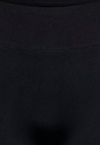 Gros plan d'une section de tissu noir avec coutures visibles et texture, montrant deux nuances légèrement différentes de matériau noir.