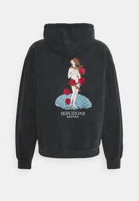 Felpa nera con un design stampato che presenta una figura tra rose rosse su uno sfondo blu, con la scritta "SEDUZIONE KAOTIKO."