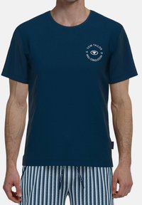 Nachtsblaues kurzärmliges T-Shirt aus Baumwolle mit rundem Ausschnitt, das ein weißes kreisförmiges Logodesign auf der linken Brust zeigt.