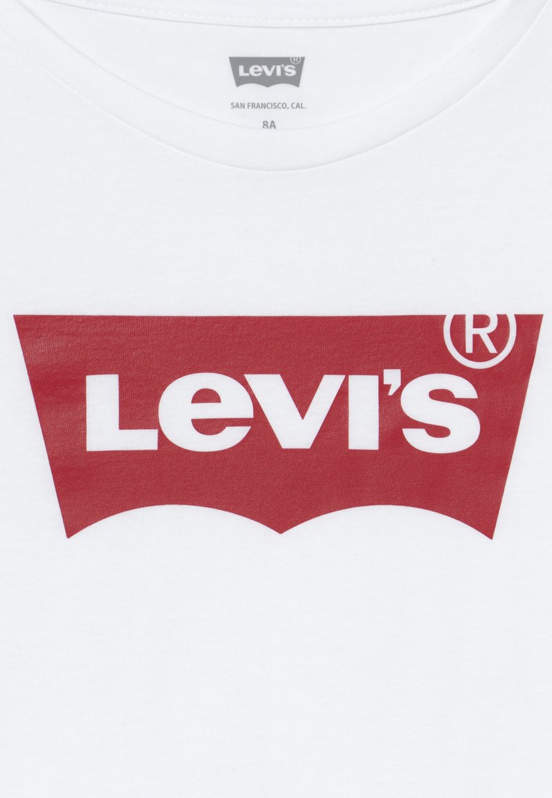 T-shirt bianco in cotone con un grande logo rosso Levi's in design curvo, con lettering bianco prominente su una texture liscia.