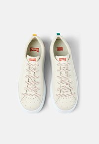 Weiße Leder-Sneaker mit rotem und orangefarbigem Branding, strukturierten Schnürsenkeln mit roten und weißen Mustern sowie bunten gelben und türkisfarbenen Akzenten.