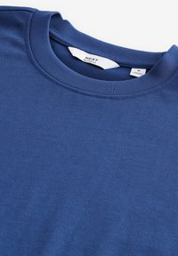 Mørkeblå bomulds T-shirt med rund hals, der har en afslappet pasform. Etiketter vises inde i kraven. Glat tekstur, ingen synlige mønstre.