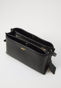 Borsa a tracolla in pelle nera con due scomparti, dettagli in zip dorati e un'etichetta. Esterno testurizzato e fodera interna liscia.