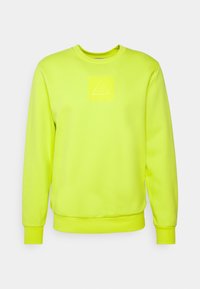 Sweat-shirt jaune vif à col rond avec manches longues et un discret écusson logo embossé sur la poitrine.