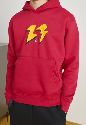 Sudadera con capucha roja y bolsillo delantero, con un diseño de rayo en colores amarillo y negro. Material de algodón, corte relajado.