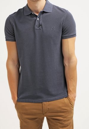 Polo bleu marine à manches courtes, avec deux boutons au col et un logo discret sur la poitrine. Tissu doux avec une texture lisse.