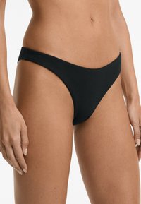 Svart ribbad bikiniunderdel med låg midja, måttlig täckning och slät textur, lämplig för badkläder.