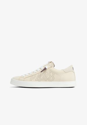 Baskets basses beiges avec semelle blanche, lacets blancs, design perforé sur le côté et détail en daim au talon sur fond blanc.
