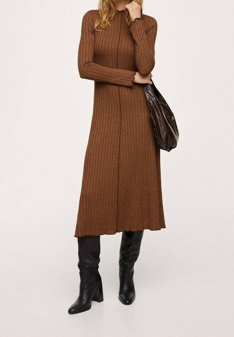 Robe longue en tricot côtelé marron à manches longues avec une coupe décontractée, présentant un ourlet fendu et un sac noir décontracté. Bottes noires à talons jusqu'aux genoux.