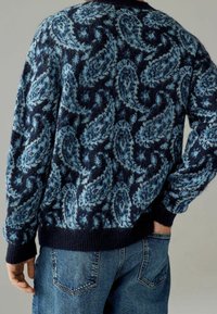 Strickpullover in dunkelblau und Blau mit einem Paisleymuster. Rippbündchen an den Ärmelabschlüssen und dem Saum; weiche Textur, lockere Passform und Rundhalsausschnitt.