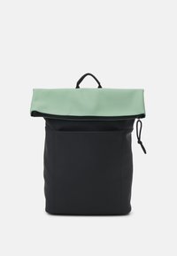 Svart ryggsäck med en vikbar mintgrön klaff. Tillverkad av slät tyg, har ett handtag på toppen och justerbar dragsko-stängning.