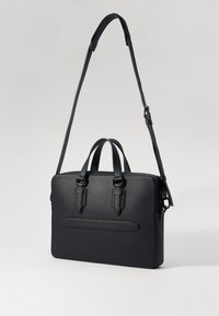 Bolsa de portátil negra con asas dobles y correa de hombro removible. Presenta una superficie texturizada, forma rectangular delgada y un bolsillo delantero.