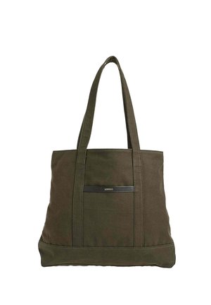 Sac fourre-tout en toile vert foncé avec deux longues anses et une petite bande logo noire portant l'inscription « Loxwood » sur la poche avant.