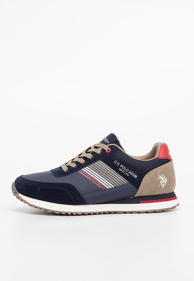 Des baskets bleu marine en suède et mesh. Détails rayés rouges et blancs sur le côté, avec un capuchon de talon beige.