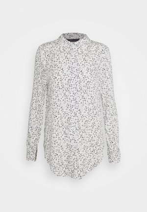 Weißes Hemd mit Knöpfen und langen Ärmeln, versehen mit einem schwarzen Blumenmuster, spitzem Kragen und abgerundetem Saum. Weiche Stofftextur.