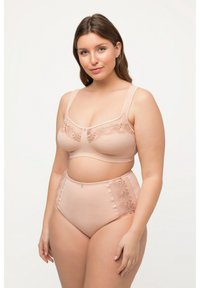 Ensemble de lingerie nude comprenant un soutien-gorge avec des détails en dentelle florale et un culotte taille haute avec des coutures accentuées et un ornement central.