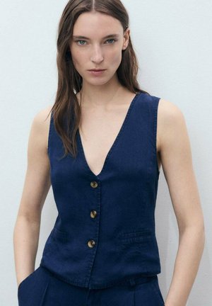 Marineblauw linnen vest met een diepe V-hals, voorzien van vijf knoopsluitingen, twee zijzakken en een getailleerde pasvorm. Soepele textuur en minimalistisch ontwerp.