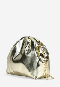 Bolso de mano dorado metálico con una textura lisa y brillante, forma redondeada, parte superior fruncida y una cadena dorada como asa.