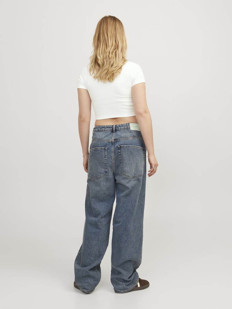 Vide ben blå denim jeans med høj talje, fem lommer og subtile slidmærker. Bæres med en tætsiddende hvid crop top.