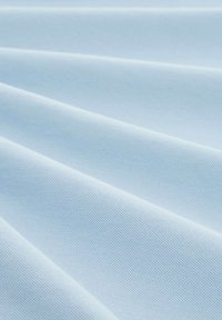 Jasnoniebieska tkanina o fakturowanej powierzchni, złożona w wiele warstw, ukazująca gładki i równomierny wzór na całym materiale.