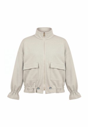 Giacca beige chiaro con zip, collo alto, due tasche anteriori con patta, polsini elasticizzati e orlo regolabile con bottoni.