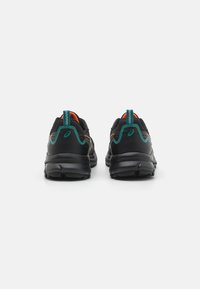 Des chaussures de sport noires avec un dessus texturé, des accents teal et un intérieur orange. Elles présentent une semelle épaisse avec un design cranté.