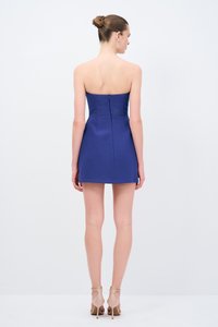 Robe mini sans bretelles en tissu bleu, corsage ajusté avec une fermeture éclair invisible au dos. Texture lisse et silhouette raffinée.