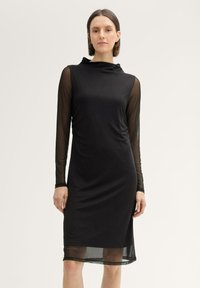 Schwarzes Kleid mit einer taillierten Silhouette, featuring lange durchsichtige Mesh-Ärmel und einen Cowl-Ausschnitt, gefertigt aus glattem Stoff. Der Saum endet oberhalb des Knies.