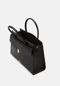 Svart läderhandväska med en strukturerad form, med dubbla handtag, en frontklaff med en guldkrok, och en öppen insida som visar fack.