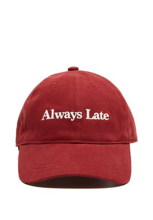 Czerwona czapka baseballowa z białym haftowanym tekstem "Always Late" z przodu, pokazana na białym tle.