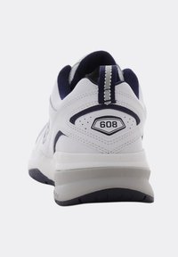 Scarpa sportiva bianca dal design robusto, con un accento blu navy sul retro e un logo esagonale etichettato "608". Tallone e suola testurizzati.