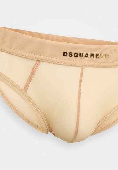 Beige apakšveļa ar elastīgu jostu, kurai ir zelta "DSQUARED2" logs, izgatavota no gludas auduma ar maziem šuvju sīkumiem.