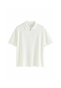 Polo in giallo pallido, maniche corte, realizzato in tessuto morbido e strutturato, con una chiusura a mezza zip sul davanti e un design di colletto classico.