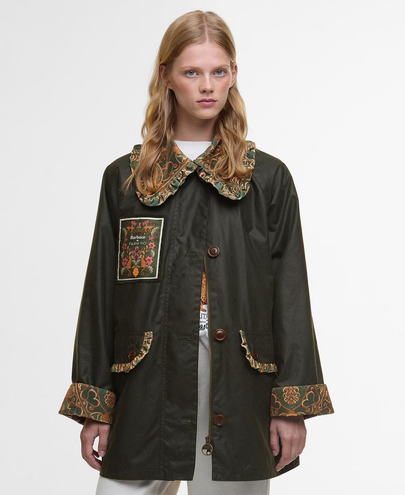 Green fabric jacket featuring a floral-patterned collar, a decorative patch, and ruffled accents on pockets and sleeve cuffs.