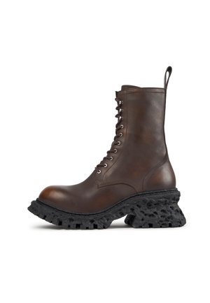 Dark brown leather lace-up boot with tall shaft and chunky black textured sole with rugged tread pattern.