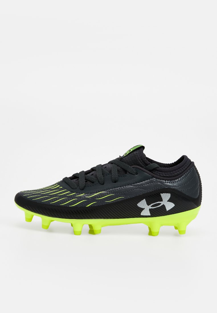 Crampons de football noirs avec un dessus texturé, des accents verts et six crampons jaunes. Logo Under Armour affiché sur le côté.