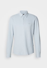 Svetlomodrá košeľa na zapínanie na gombíky s dlhými rukávmi. Vyrobená z textúrovaného materiálu s klasickým golierom, disponuje jemným logom na hrudi a manžetami na gombíky.