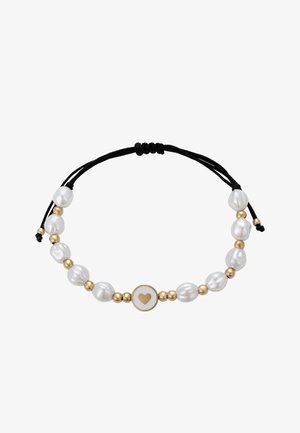 Verstelbare armband met witte gestructureerde parels, gouden kralen en een cirkelvormige bedel met een hartontwerp, vastgemaakt met een zwarte koord.