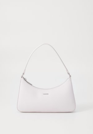 Sac à épaule blanc Calvin Klein avec fermeture éclair supérieure incurvée et courte bandoulière réglable sur fond uni.