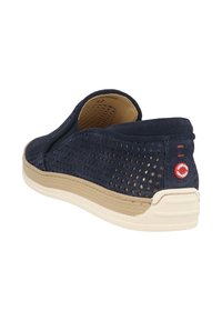 Scarpa slip-on navy in suede perforato, con suola in gomma beige e un accento con logo circolare sul tallone.