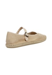 Zapato plano de ante beige con puntera redonda, correa al tobillo y suela de yute trenzada. Cuenta con una pequeña hebilla de metal para ajuste.